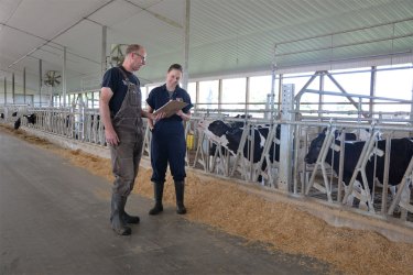 Male dairy farmer talking with female ABS genetic advisor
